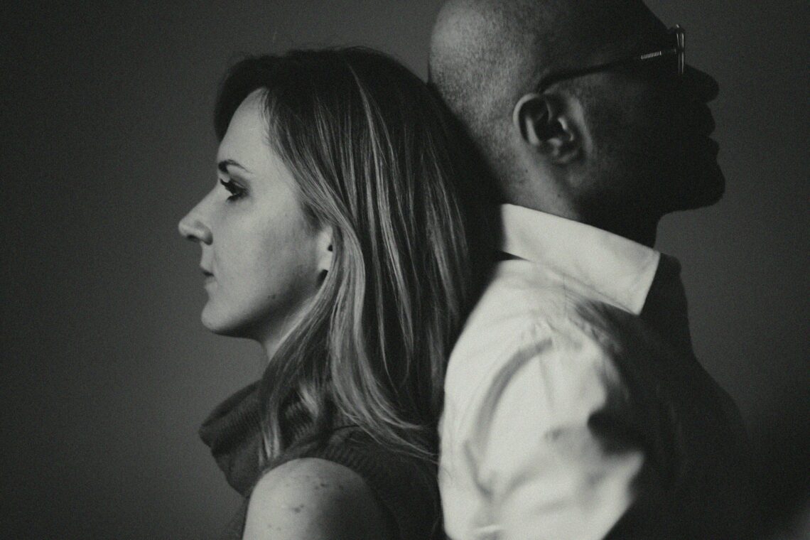 Two adults standing back-to-back, representing their difficult co-parenting relationship