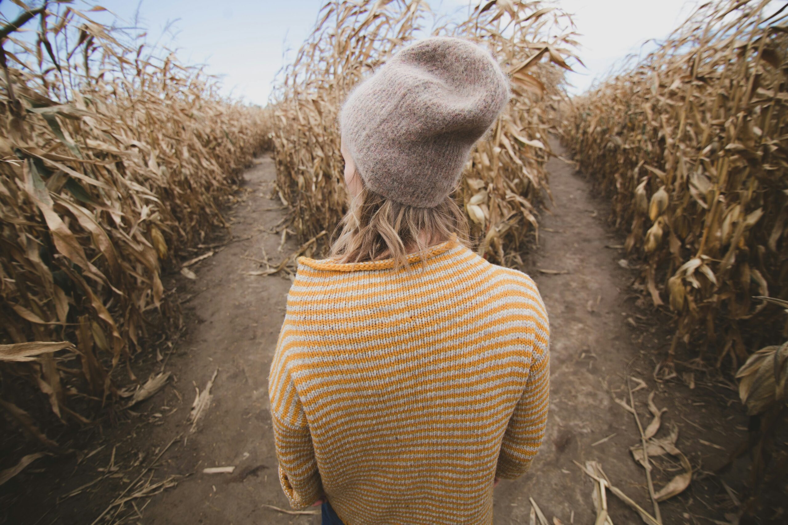 Woman standing in front of two paths, deciding which one to take.