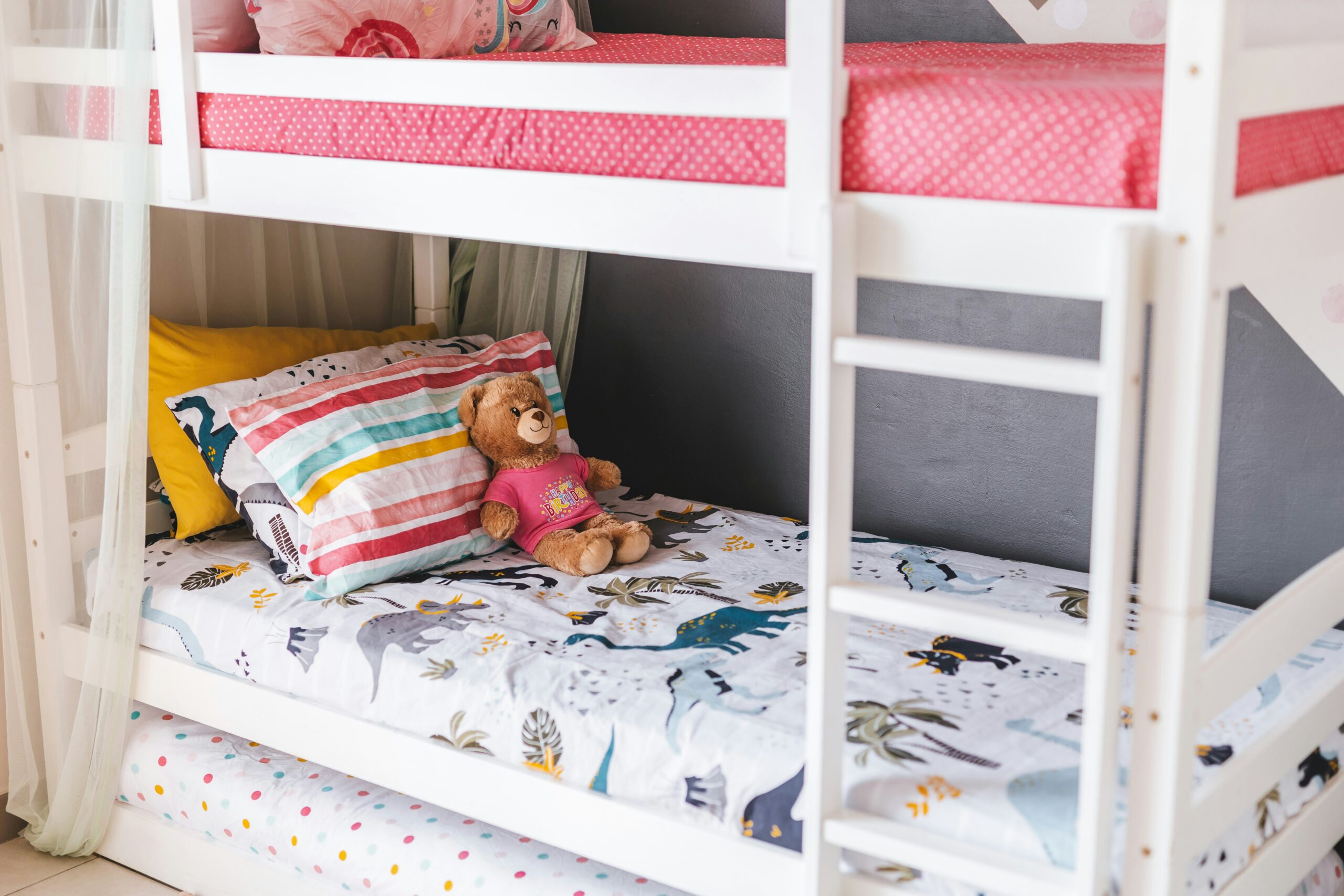 Bunkbeds shown with child's blanket and stuffed animal.